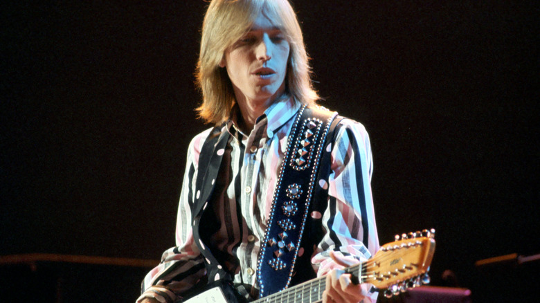 Tom Petty playing guitar onstage