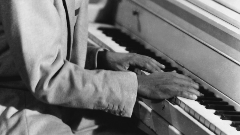 Ray Charles playing the piano with his head out of frame