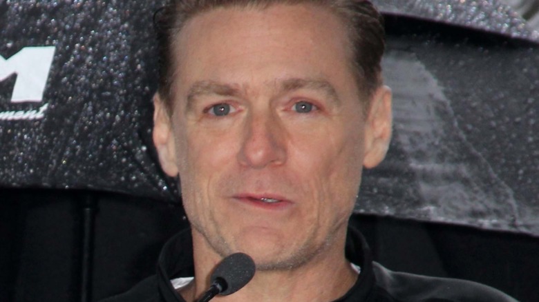 Bryan Adams behind a microphone