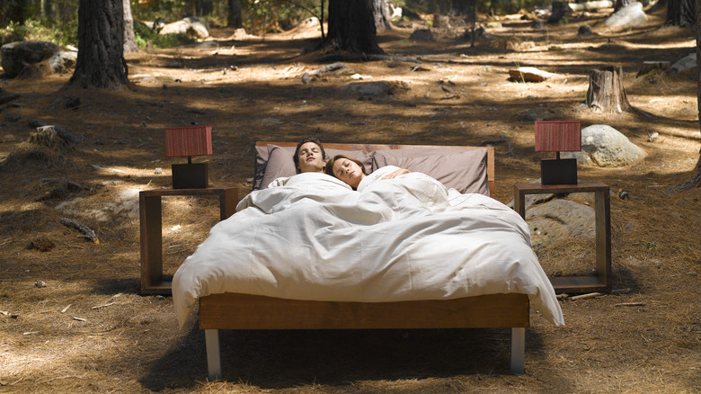 Couple sleeping in bed in the forest