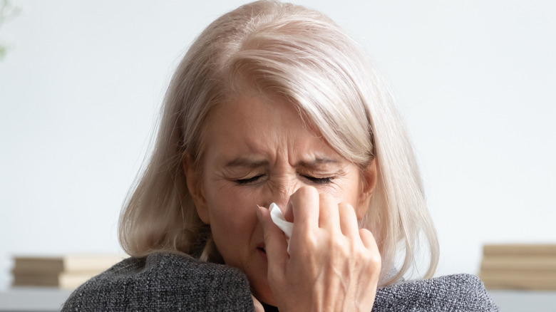 Woman blowing her nose