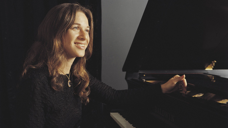 Carole King smiling at piano