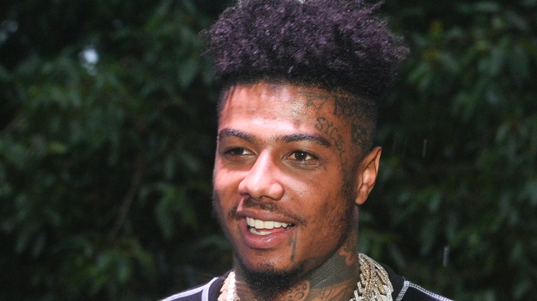 blueface wearing gold chains and smiling