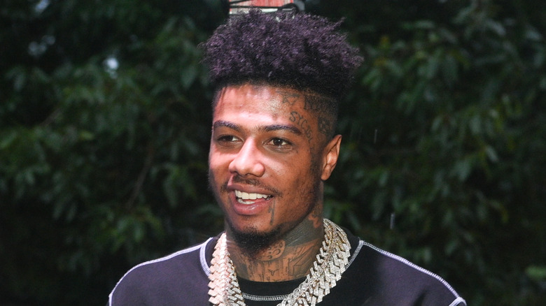blueface wearing gold chains and smiling
