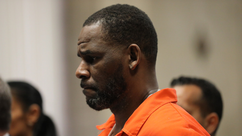R. Kelly in court looking glum wearing orange jumpsuit