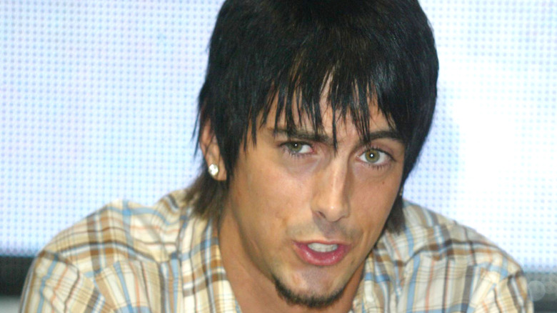 Ian Watkins in checkered shirt gritted teeth