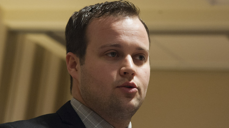 Josh Duggar in suit talking indoors