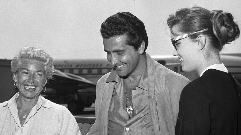 lana turner, johnny stompanato, and cheryl crane by plane smiling