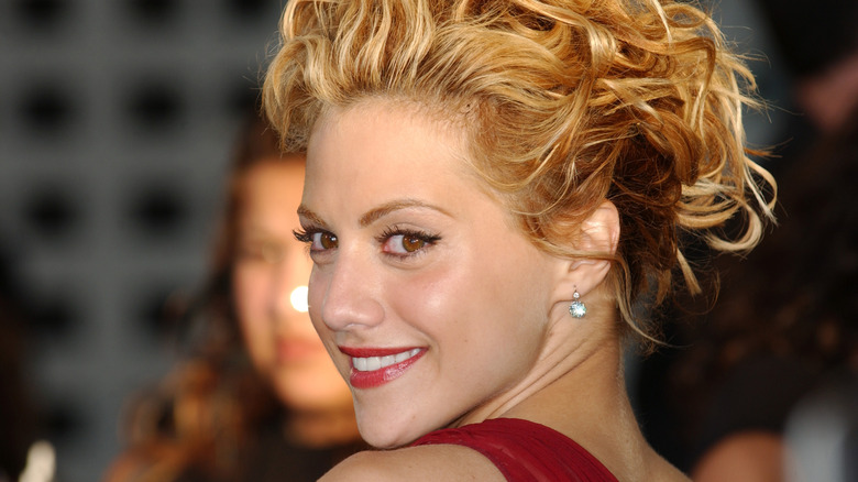 Brittany Murphy smiling in red dress looking over her shoulder