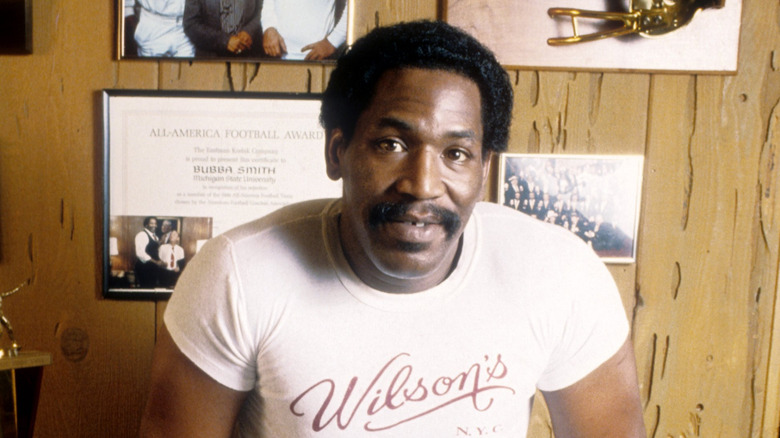 Bubba Smith smiling with football awards