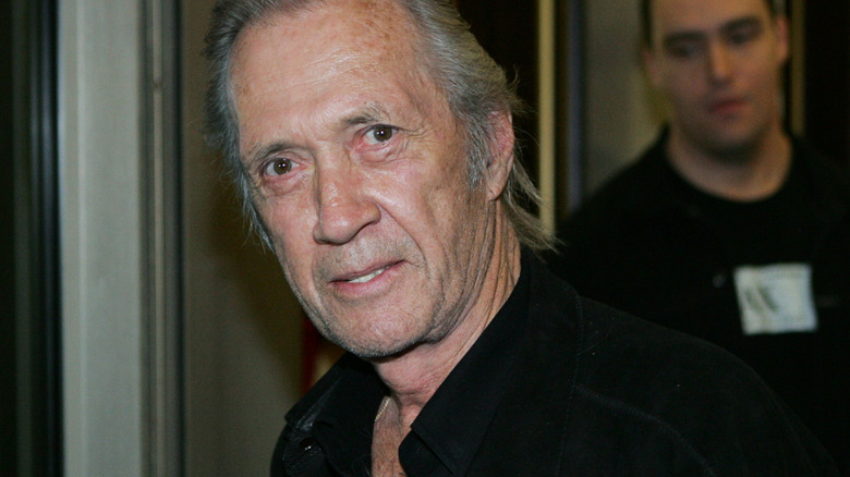 David Carradine in black jacket staring