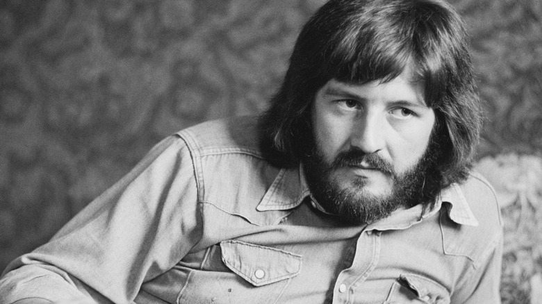 John Bonham laying in light shirt with beard