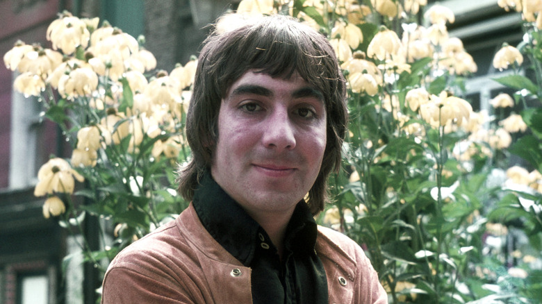 Keith Moon posing in front of flowers