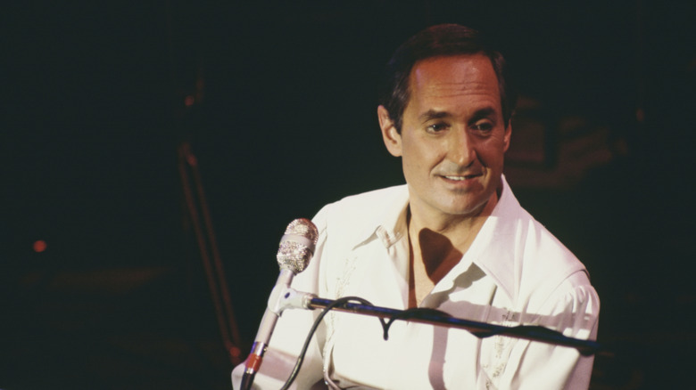 Neil Sedaka seated at piano with microphone