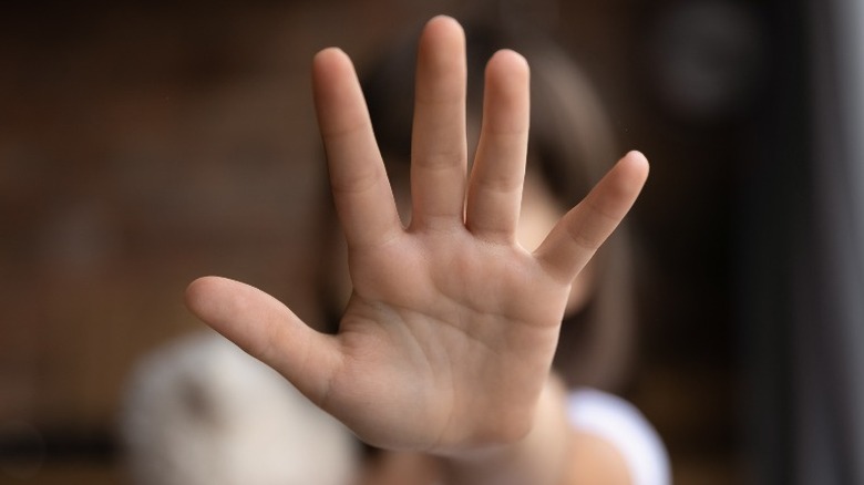 abuse victim holding up her hand