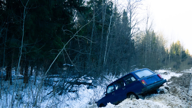 stock photo of wrecked car in snowy ditch