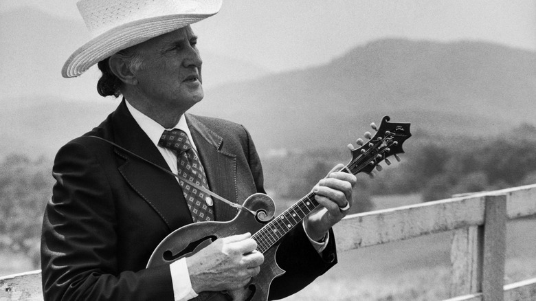 Bill Monroe playing the mandolin outside