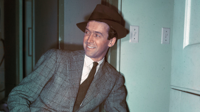 Jimmy Stewart smiling in grey suit and brown hat