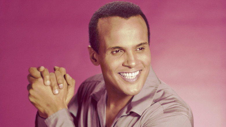 Harry Belafonte smiling and clasping his hands