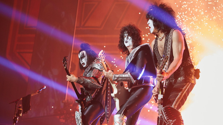 Kiss performing on stage in front of exploding fireworks.