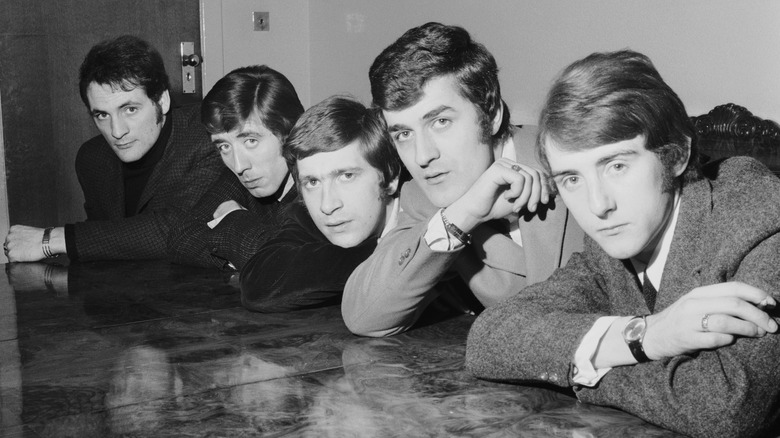 The Moody Blues suited lean on a table