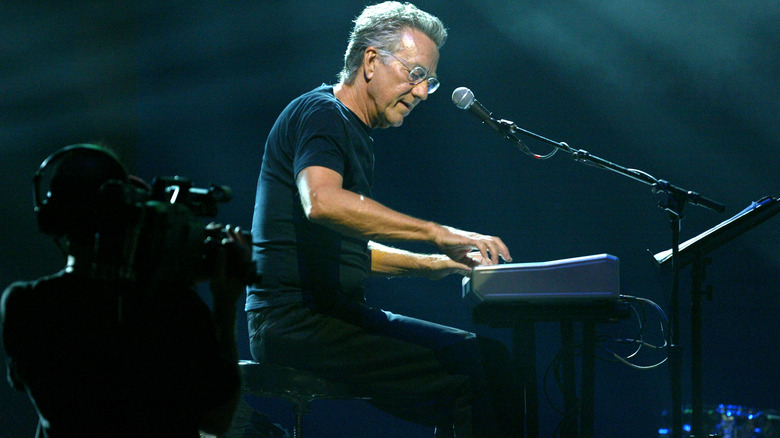 Ray Manzarek performing onstage sitting keyboard
