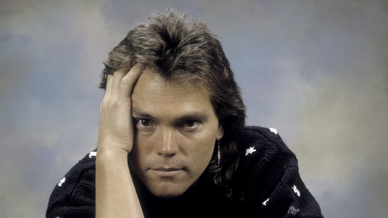 Timothy Schmidt of the Eagles holding his head (1980s)