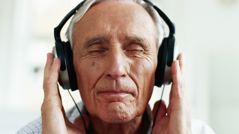 Older white man listening to music through headphones