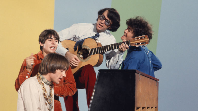 The Monkees posing for band photo with guitar and piano