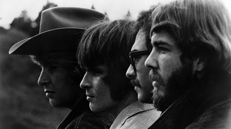 The four members of Creedence Clearwater Revival posing in front of a black background.