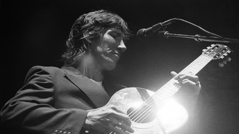 Roger Waters playing guitar on stage