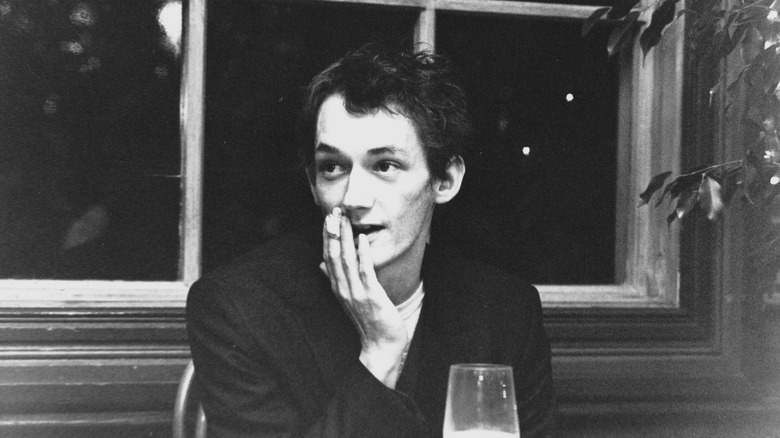 Keith Levene sitting at a table with a glass of wine