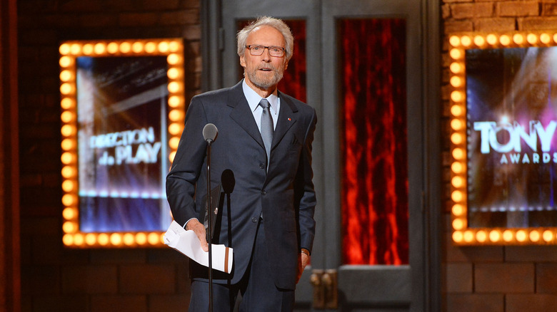 Clint Eastwood radio city music awards in front of mic holding paper
