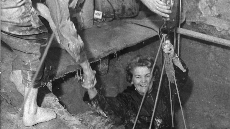 woman smiling while being helped out of tunnel
