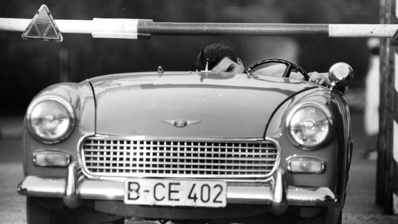Lowered sports car driving under barrier
