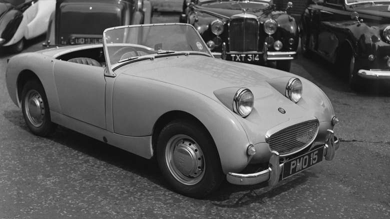 an austin-healey sprite parked with other vintage cars