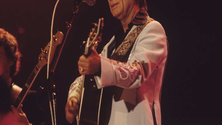 George Jones playing guitar on stage