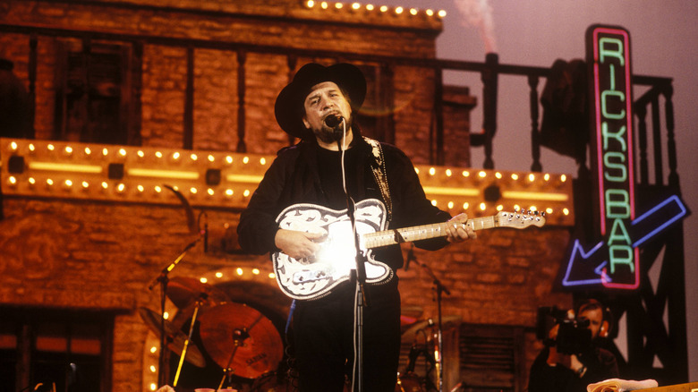 Waylon Jennings performing in front of an elaborate Western set