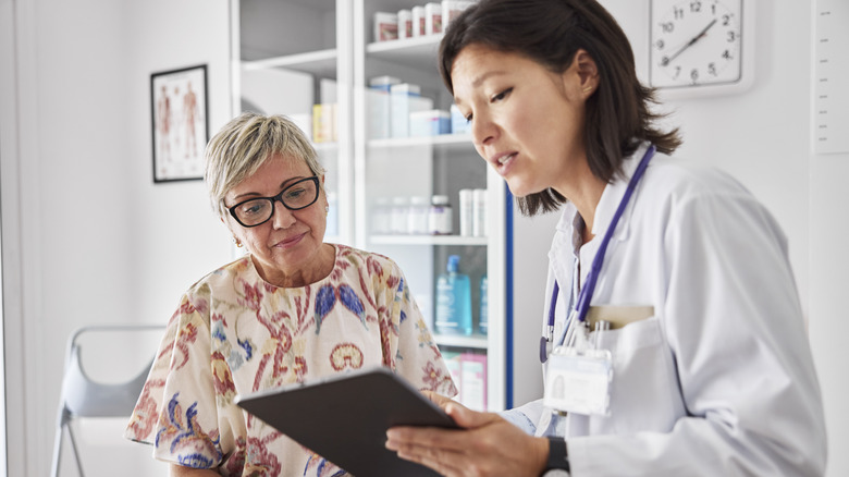 Female doctor sharing electronic test results with patient at clinic