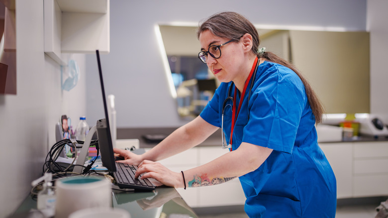 A female healthcare professional using a laptop