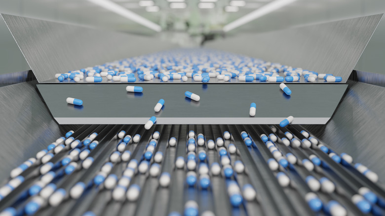 A production line of blue and white capsules