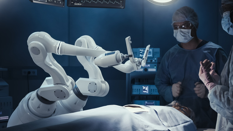 Surgeons stand in front of the Da Vinci surgical system