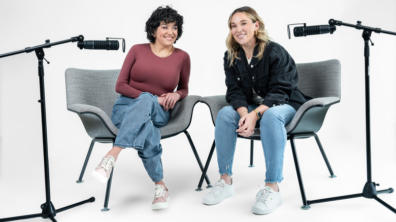 Brit Prawat and Ashley Flowers smiling with mics