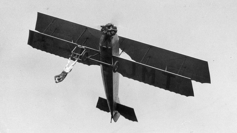 man dangling from airplane