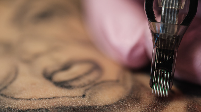 closeup of a tattoo artist using a tattoo gun