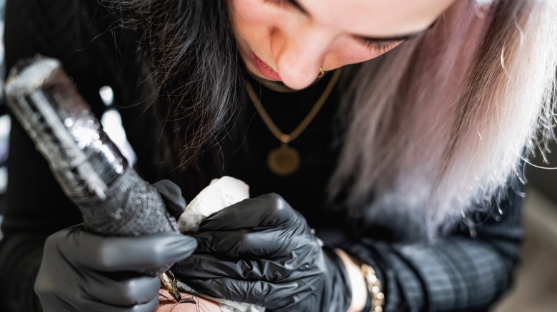 tattoo artist working on filling in an outline