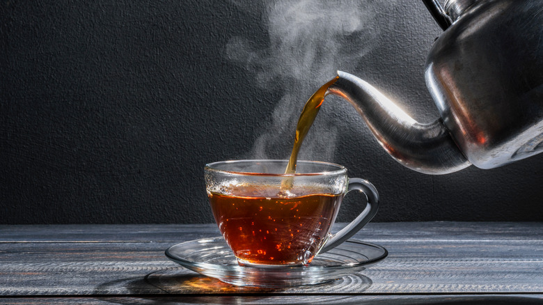 Kettle pouring steaming hot tea