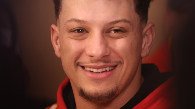 Patrick Mahomes smiling in a Chiefs sweatshirt