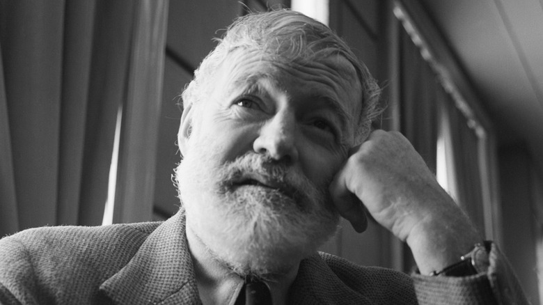 Hemingway grey-haired leaning on fist