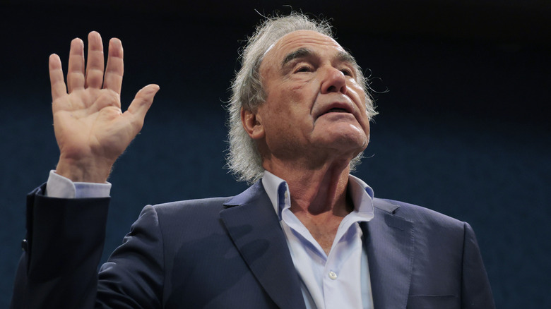 Oliver Stone raises his hand in oath